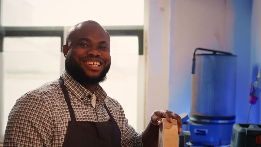 portrait of jolly man inspecting wood piece, evaluating lumber block