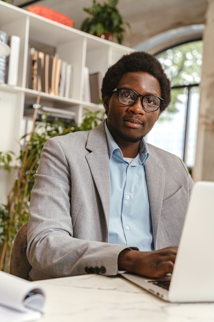 Succession Planning: The Secret to Building Businesses That Outlive Their Founders Confident professional man in glasses working on a laptop in a modern office setting.